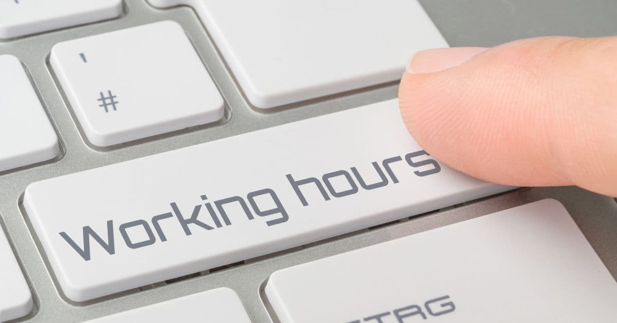 Dedo pressionando a tecla “Working hours” de um teclado