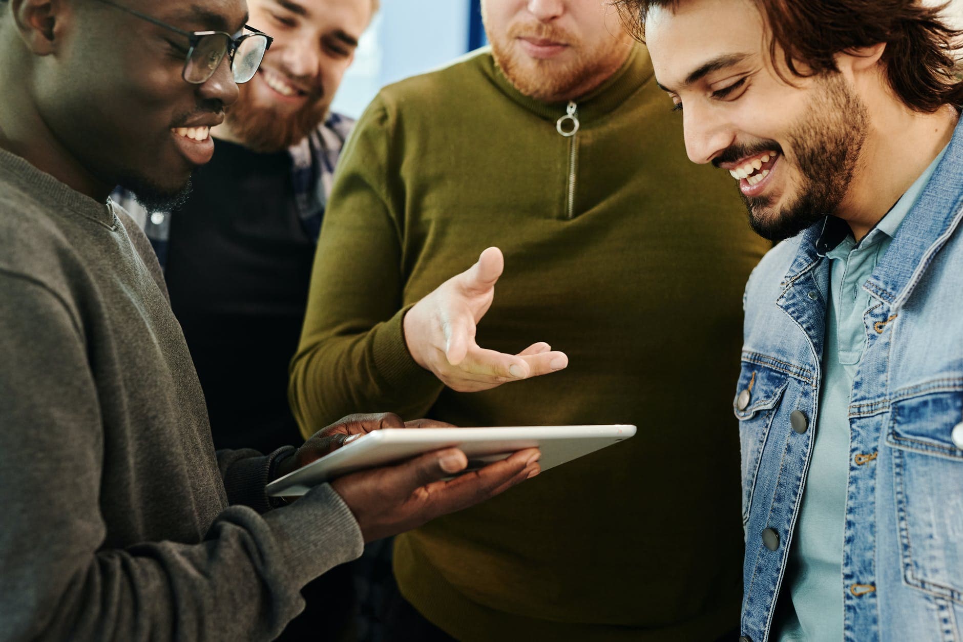 Colegas sorrindo enquanto discutem uma ideia em um tablet